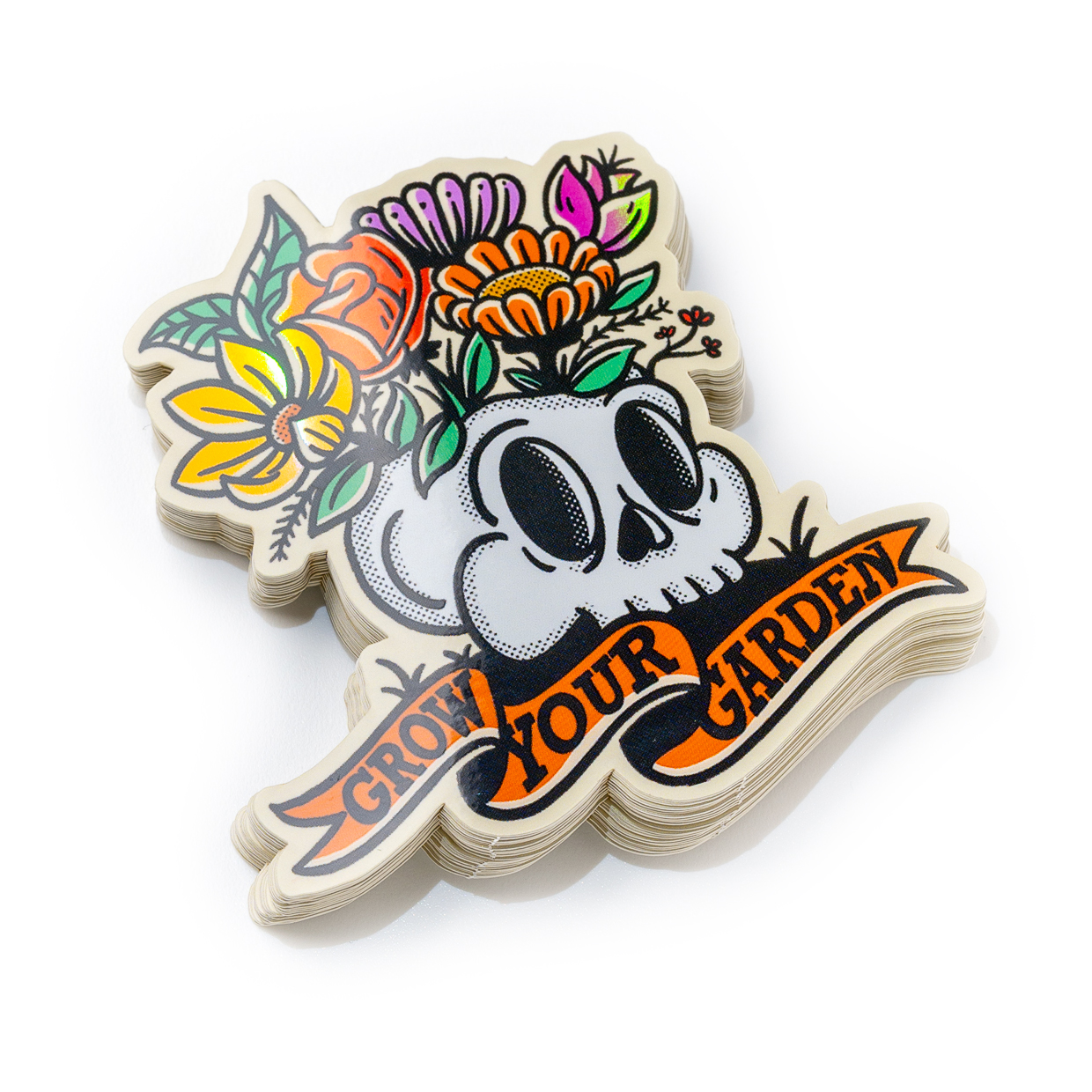 Calavera con flores coloridas y la frase "Grow Your Garden" en una cinta anaranjada.