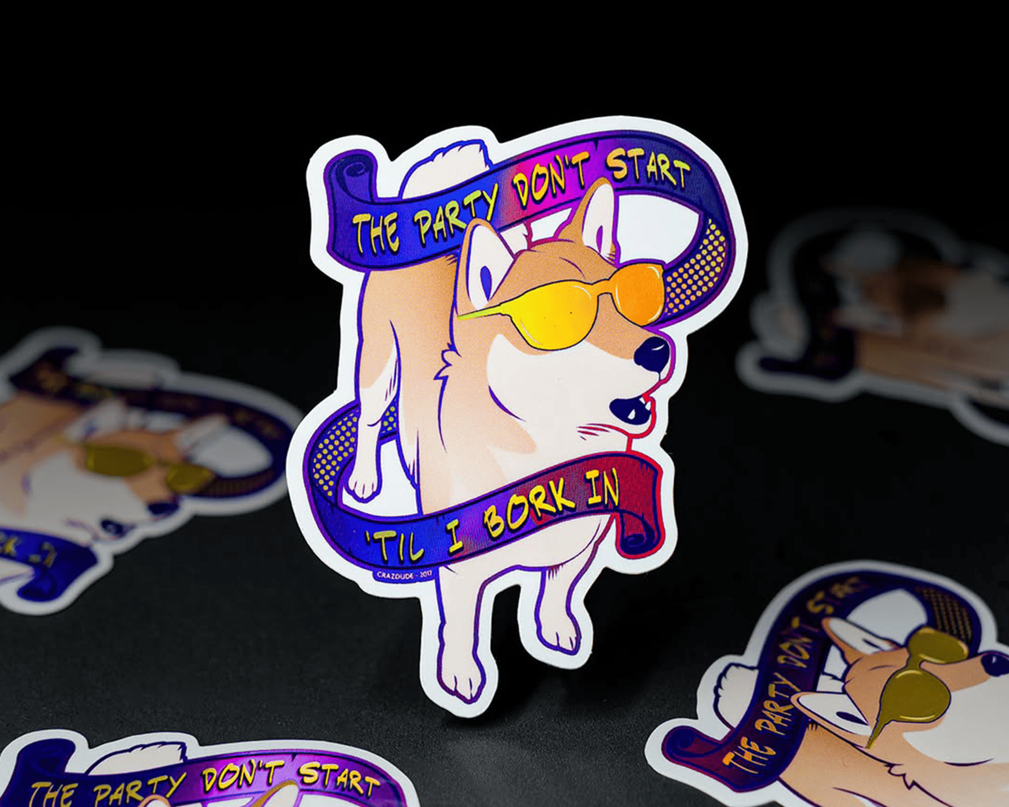 Holographic sticker of a cool dog wearing sunglasses with text: "The party don't start 'til I bark in," on a colorful ribbon.