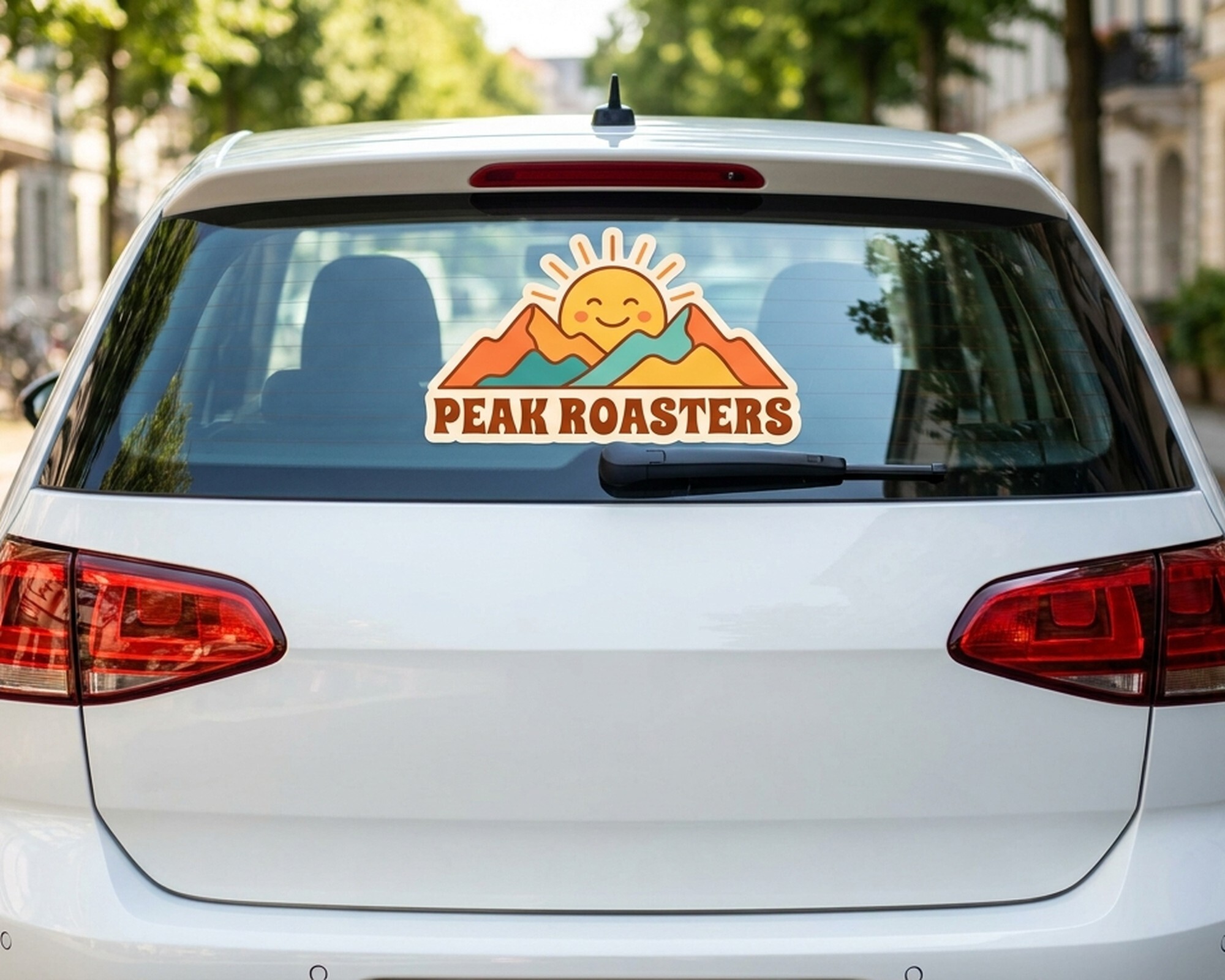 Calcomanía personalizada troquelada con un logotipo de sol y montañas y el texto «Peak Roasters» en la luna trasera de un coche
