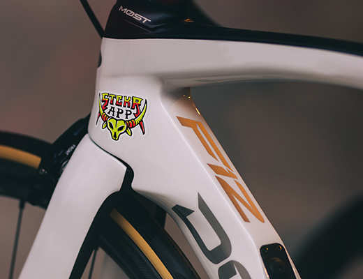 A white bicycle with a heavy duty stickerapp logo sticker applied