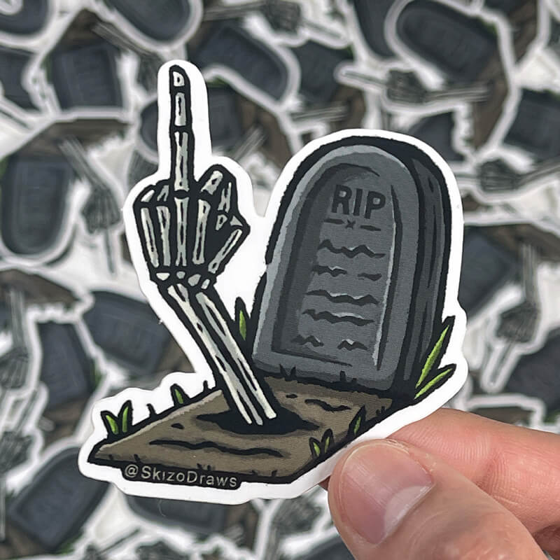 Pegatina troquelada de vinilo de una tumba con el texto «RIP» y un brazo de esqueleto que sale del suelo haciendo una peineta, sobre un fondo de pegatinas.